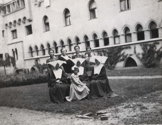 Marlaine Khan la rescapée(avec un ruban dans les cheveux assise devant) avec  les soeurs du monastère. Credit: COLL.YAD